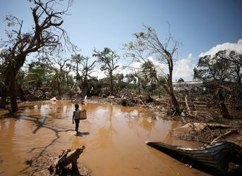Uma criança entra na povoação de Buzi, perto da Beira, ao recuarem as águas, após o ciclone "Idai" © Mike Hutchings / REUTERS