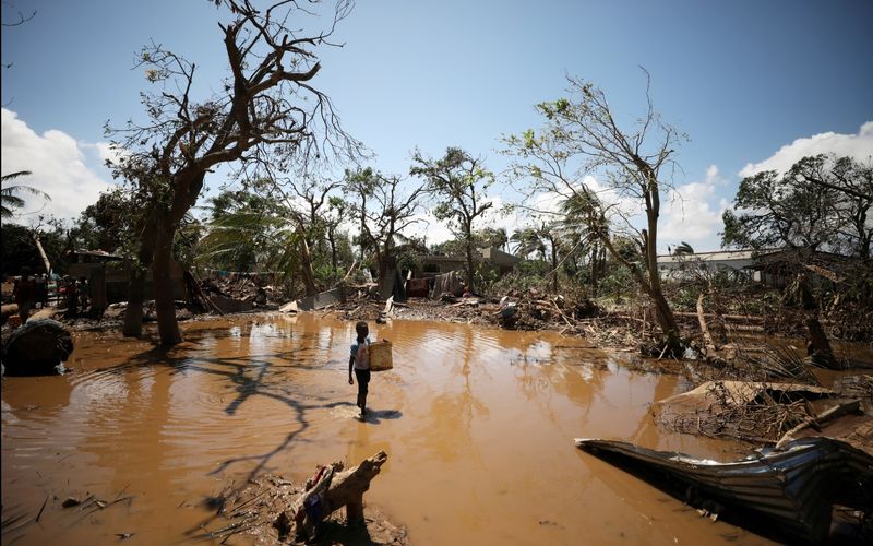 Uma criança entra na povoação de Buzi, perto da Beira, ao recuarem as águas, após o ciclone "Idai" © Mike Hutchings / REUTERS